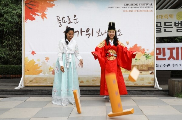 서울 성동구 서울캠퍼스에서 10일 열린 ‘외국인 유학생과 함께하는 추석행사’에 참석한 학생들이 윷놀이를 하고 있다. (사진: 한양대 제공)