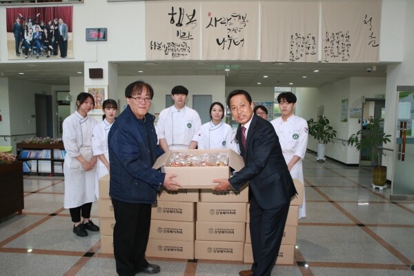 신성대 봉사단 학생들이 직접 만든 빵을 이명철 관장(우측)에게 전달하고 있다.
