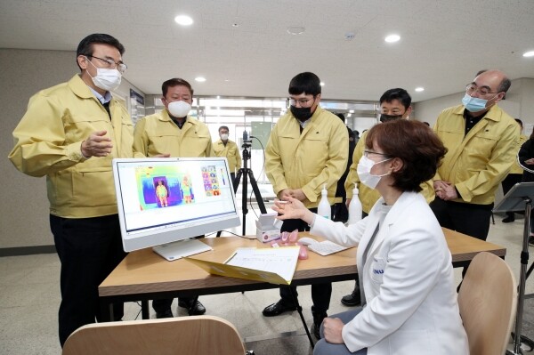 강원대학교 관계자가 2월 21일(금) 오전 외국인 유학생 자율격리 생활관 입구에 설치된 열감지카메라를 이용해 출입자에 대한 체온을 측정하는 모습을 시연하고 있다. 이주경 학생처장(코로나19예방대책위원장, 왼쪽 2번째), 오순문 사무국장(맨 왼쪽), 채희문 학생생활관장(맨 오른쪽) (사진: 강원대 제공)
