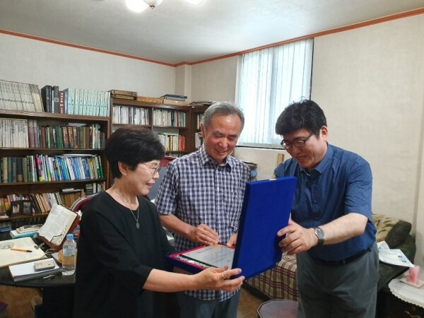 디지털서울문화예술대학교는 15일 스승의 날을 맞아 ‘제6기 남윤철 장학금’을 수여했다. 사진은 육효창 부총장(오른쪽)이 2019년 6월 충북 청주 남윤철 교사 유가족(남수현 교수, 홍경옥 여사)을 방문해 감사패를 전달하는 모습.