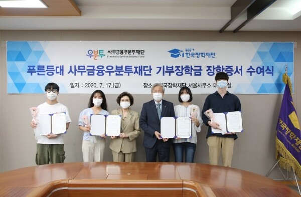 7월 17일(금), 한국장학재단 서울사무소 대회의실에서 이정우 한국장학재단 이사장(오른쪽 3번째), 신필균 사무금융우분투재단 이사장(왼쪽 3번째)과 장학생들이 장학증서 수여식에 참석하여 기념촬영을 하고 있다. (사진: 한국장학재단 제공)