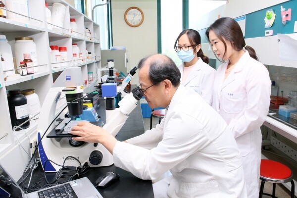 울산대 생명과학부 권병석 교수가 메타염증연구센터 실험실에서 연구원들과 함께 신장암에 효과가 기대되는 면역관문 차단제 개발을 위한 신장암 배양 세포를 관찰하고 있는 모습