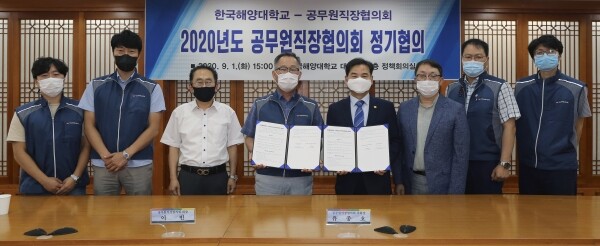 도덕희 한국해양대 총장(오른쪽에서 네 번째)과 이빈 한국해양대 공직협 회장(왼쪽에서 네 번째)이 합의서를 들고 관계자들과 기념촬영을 하고 있다. (사진: 한국해양대 제공)