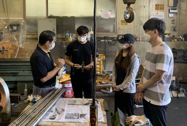광남정밀 권년택 대표가 산기대 김동현·임수영·원용준 씨가 제작한 부품을 살펴본 뒤 문제점을 자문 해주고 있다.