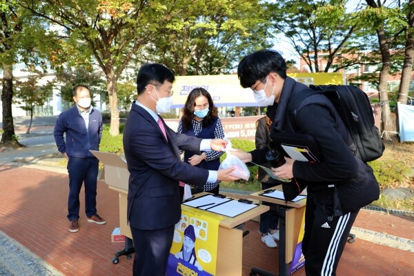 정병석 전남대 총장이 19일 중간고사를 치르기 위해 등교한 학생에게 도시락을 나눠주고 있다.
