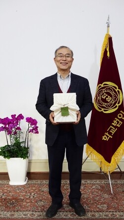 학교법인 덕성학원 안병우 이사장이 ‘핸드 인 핸드 캠페인’에 동참했다. 안 이사장이 연규홍 한신대학교 총장에게 보내는 사회적경제기업의 제품을 들고 응원의 마음을 전하고 있다. (사진=학교법인 덕성학원 제공)