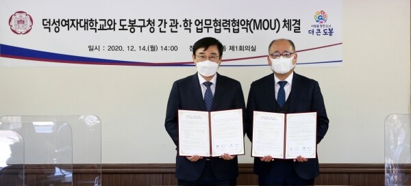 덕성여대와 도봉구청은 14일 ‘관·학 상생발전을 위한 협력 협약’을 체결했다. 김진우 덕성여대 총장직무대리(우)와 이동진 도봉구청장이 협약서를 들고 기념촬영을 하고 있다. 사진=덕성여대 제공