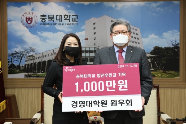 충북대학교 경영대학원 원우회가 17일 대학본부 5층 접견실을 찾아 경영대학 교육환경개선기금으로 사용해 달라며 1천만원을 기탁했다. 김수갑 총장(우)과 신은주 총무(좌)가 기념촬영을 하고 있다. (사진=충북대 제공)