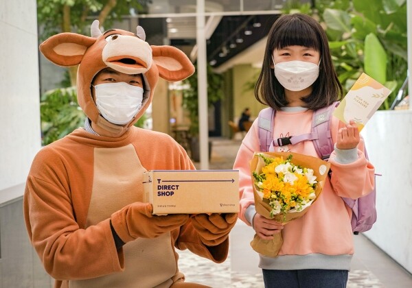 캐릭터 복장을 한 SKT 배송 담당자가 고객에게 스마트폰과 꽃다발, 맞춤선물 등을 전달하는 모습. 사진=SK텔레콤 제공
