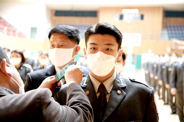 영남이공대학교 부사관·우정공무원 계열은 15일 오전 11시 천마체육관에서 ‘부사관과 승급 및 제복 착용식’을 개최했다. 김용현 계열장이 대표 학생의 견장 착용을 돕고 있다. 사진=영남이공대 제공