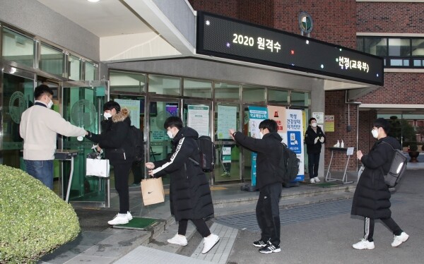 광주광덕고에서 2021학년도 수능을 치르는 수험생들이 시험장 입실 전 손소독을 하고 있다. 사진=광주교육청 제공