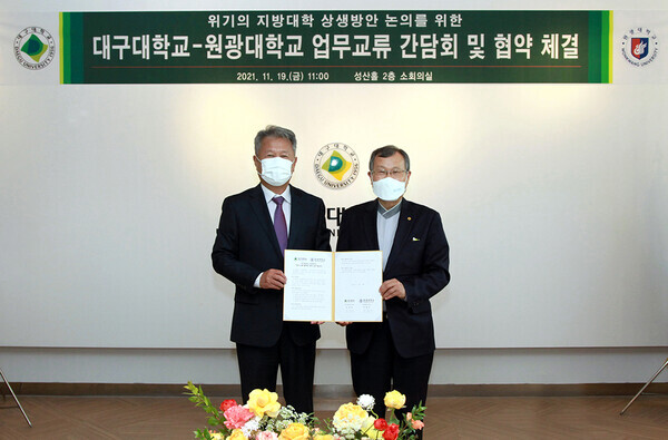 김상호(왼쪽) 대구대 총장과 박맹수 원광대 총장이 업무협약 체결 후 협약서를 펼쳐보이고 있다. 사진=원광대 제공