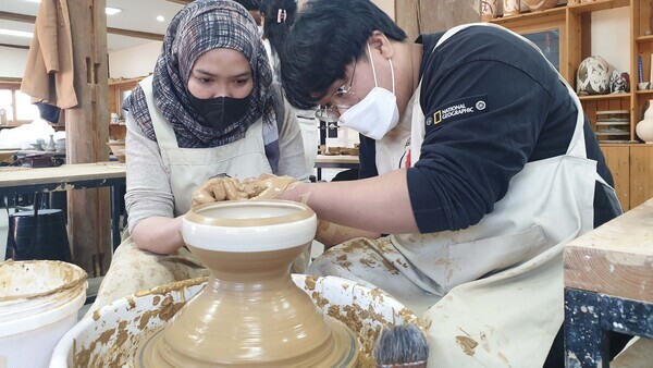 인제대 유학생(왼쪽)이 김해가야테마파크에서 도자기 물레 체험을 하고 있다. 사진=인제대 제공