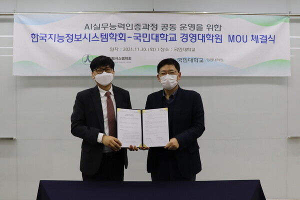 국민대 경영대학원과 한국지능정보시스템학회 관계자들이 인공지능(AI) 실무능력 인증과정 개발과 운영을 위한 업무협약을 체결하고 협약서를 펼쳐보이고 있다. 사진=국민대 제공