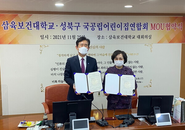 박두한(왼쪽) 삼육보건대 총장과 최명숙 성북구국공립어린이집연합회 회장이 11월 26일 업무협약을 맺고 협약서를 들어보이고 있다. 사진=삼육보건대 제공