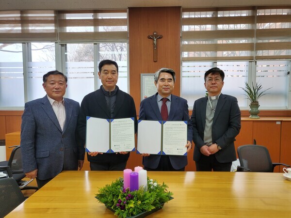 김덕현(왼쪽에서 세 번째) 가톨릭관동대 총장이 박현창(〃 두 번째) 효명고등학교 교장과 교육활동 협력 협약을 체결하고 협약서를 펼쳐보이고 있다. 사진=가톨릭관동대 제공