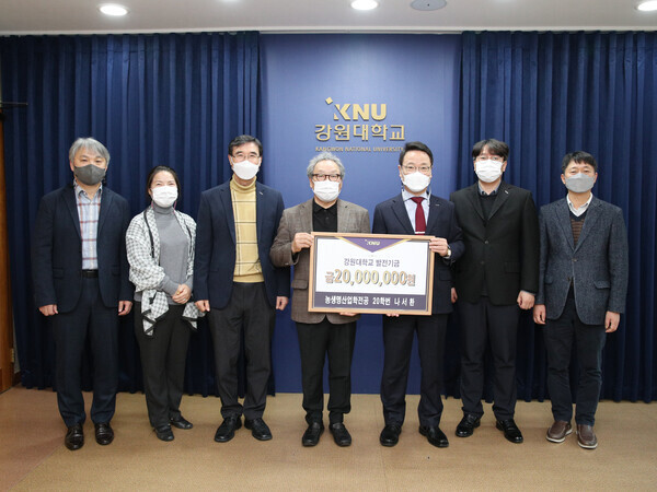 지승공예 명인이자 만학도로 강원대 농업생명산업학전공에 재학 중인 나서환씨(가운데)와 김헌영(왼족에서 다섯번째) 강원대 총장 등이 나씨의 발전기금 전달식 후 기념촬영을 하고 있다. 사진=강원대 제공