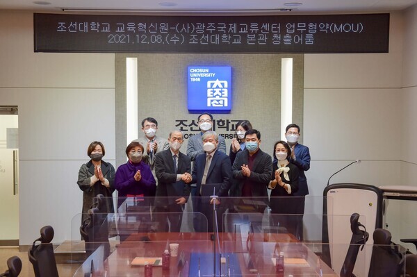 조훈(앞줄 왼쪽에서 네 번째) 조선대 교육혁신원장과 신경구(〃세 번째) 광주국제교류센터 소장이 업무협약을 체결하고 악수를 나누고 있다. 사진=조선대 제공