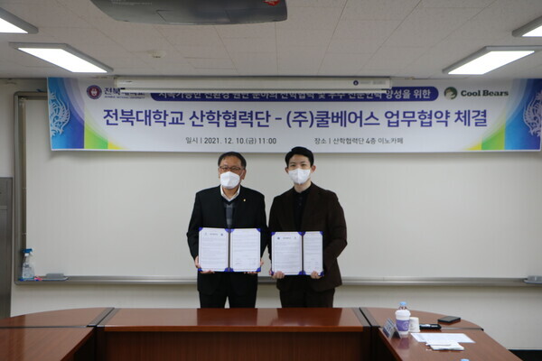 조기환(왼쪽) 전북대 산학협력단장과 이민재 쿨베어스 사장이 업무협약을 체결한 뒤 협약서를 펼쳐보이고 있다. 사진=전북대 제공