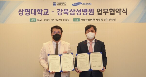  홍성태(오른쪽) 상명대 총장과 신현철 강북삼성병원장이 지난 15일 업무협약을 체결한 뒤 협약서를 펼쳐보이고 있다. 사진=상명대 제공