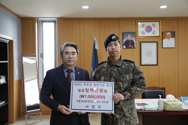 김덕현 가톨릭관동대 총장과 서영우 ROTC 후보생이 대학발전기금 전달식에서 기탁증서를 들어보이고 있다. 사진=가톨릭관동대 제공