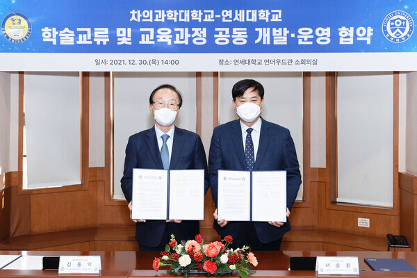 서승환(오른쪽) 연세대 총장과 김동익 차의과학대 총장이 30일 학술교류 협정 및 교육과정 공동 개발‧운영 협약을 체결한 뒤 협약서를 펼쳐보이고 있다.