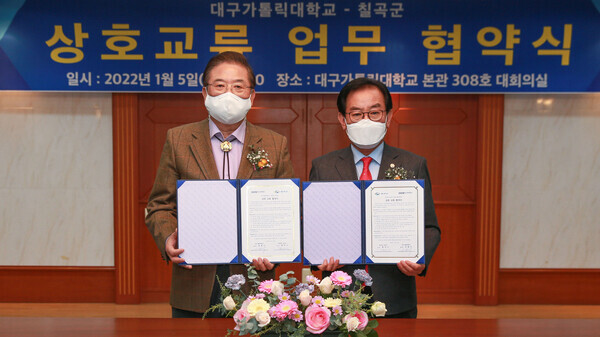 우동기(왼쪽) 대구가톨릭대 총장과 백선기 칠곡군수가 5일 상호교류 업무 협약을 맺고 협약서를 펼쳐보이고 있다.  사진=대구가톨릭대 제공