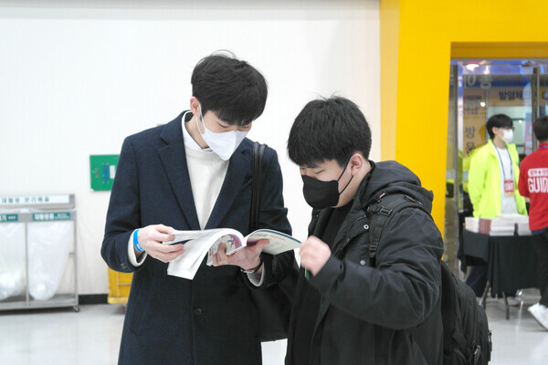 박람회장을 찾은 수험생들이 안내책자에 수록된 대학 정보를 살펴보고 나누고 있다. 사진=임지연 기자