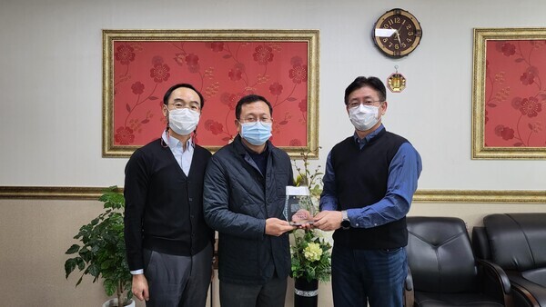 김유석(가운데) 정우화인 대표가 군산대에 장학금을 기부하기로 하고 감사패를 전달받고 있다. 사진=군산대 제공