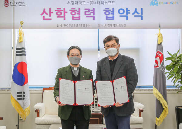 심종혁(왼쪽) 서강대 총장과 박창신 캐리소프트 대표가 업무협약을 체결하고 협약서를 들어보이고 있다. 사진=서강대 제공