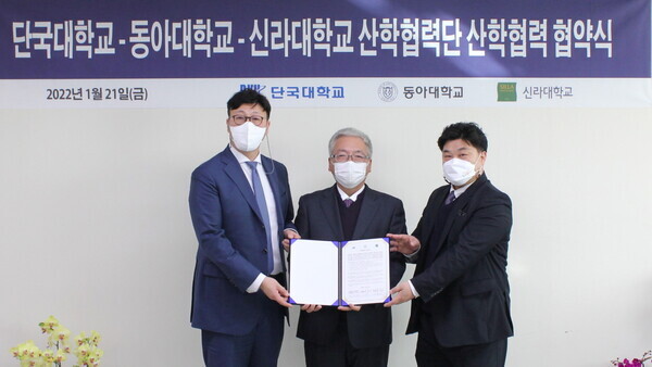 (왼쪽부터)박현태 동아대 건강과학대학장과 백동헌 단국대 산학협력단장, 이범진 신라대 산학협력단장이 업무협약을 체결하고 협약서를 펼쳐보이고 있다. 사진=동아대 제공