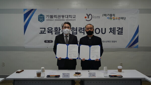 김덕현(왼쪽) 가톨릭관동대 총장과 이용권 가톨릭아동청소년재단 이사장이 업무협약을 체결하고 협약서를 펼쳐보이고 있다. 사진=가톨릭관동대 제공