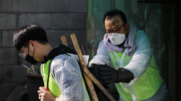 가톨릭대 까리따스 봉사단 학생이 봉사활동에 참여해 연탄을 실어나르고 있다. 사진=가톨릭대 제공
