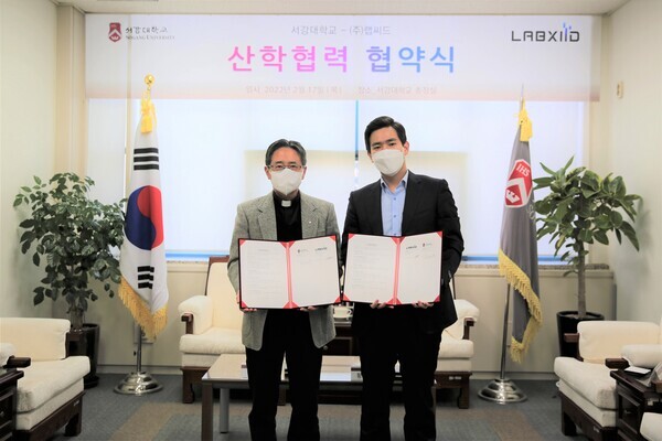 심종혁(왼쪽) 서강대 총장과 황동주 랩씨드 대표가 업무협약을 체결하고 협약서를 펼쳐보이고 있다. 사진=서강대 제공