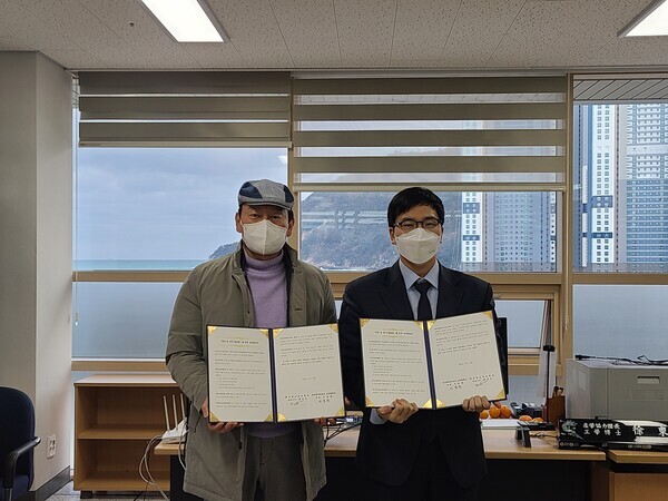 한국해양대 산학협력단과 토탈소프트뱅크 관계자가 업무협약을 체결하고 협약서를 펼쳐보이고 있다. 사진=한국해양대 제공