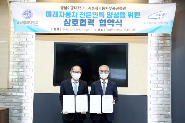이재용(왼쪽) 영남이공대 총장과 성명호 지능형자동차부품진흥원 원장이 협약을 맺은 후 협약서를 펼쳐보이고 있다. 사진=영남이공대 제공