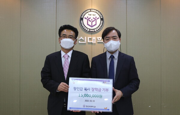 황인갑(왼쪽) 청계서부교회 목사와 강성영 한신대 총장이 장학금 전달식에서 기탁증서를 들어보이고 있다. 사진=한신대 제공