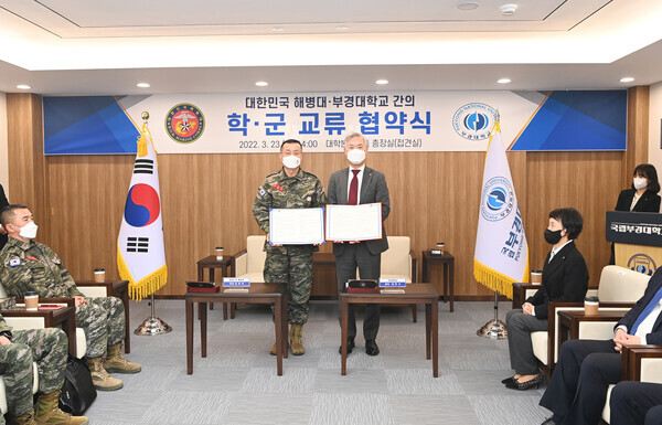 장영수(오른쪽) 부경대 총장과 김태성 해병대사령관이 학‧군 교류 협약을 체결한 뒤 협약서를 펼쳐보이고 있다. 사진=부경대 제공