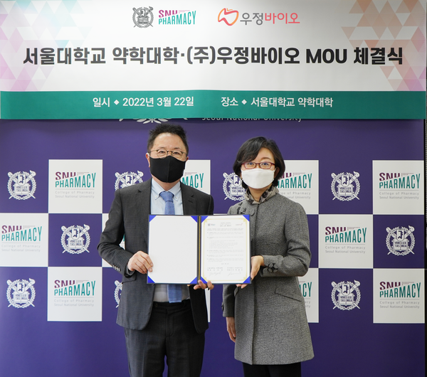 서울대 약학대학과 우정바이오의 업무협약식에서 참석자들이 협약서를 펼쳐보이고 있다. 사진=서울대 제공
