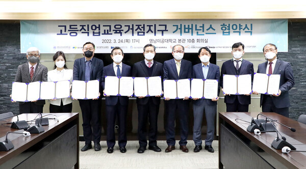 영남이공대와 지역 산·관·연 9개 기관이 협약식을 마치고 협약서를 펼쳐보이고 있다. 사진=영남이공대 제공