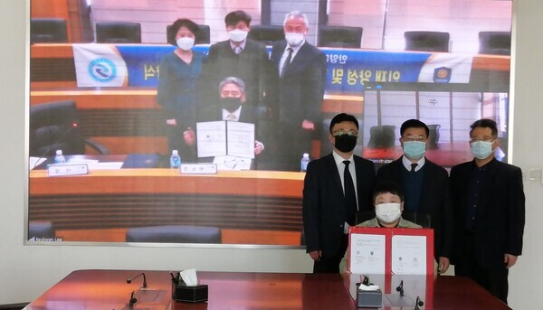 안양대와 중국 강소재경직업기술대 관계자들이 원격 화상회의를 통해 업무협약을 체결한 후 협약서를 들고 기념촬영하고 있다. 사진=안양대 제공
