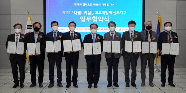 강대성(왼쪽에서 세 번째) 동아대 부총장과 김석준(가운데) 부산시 교육감 등 참석자들이 2022 고교학점제 선도지구 업무협약식에서 협약을 체결한 뒤 협약서를 펼쳐보이고 있다. 사진=부산시교육청 제공