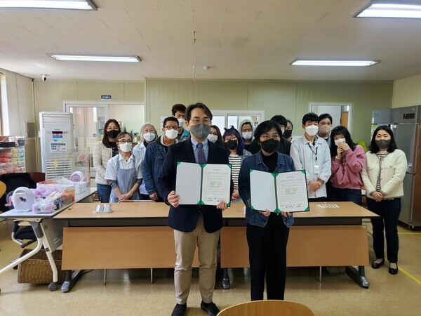 조지용(왼쪽) 건양대 사회봉사센터장과 하주현 논산발그래일터 대표가 업무협약을 체결한 뒤 협약서를 펼쳐보이고 있다. 사진=건양대 제공