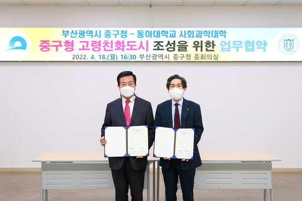 윤은기(오른쪽) 동아대 사회과학대학장과 최진봉 부산 중구청장이 업무협약식에서 협약서를 펼쳐보이고 있다. 사진=동아대 제공