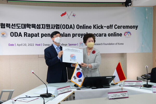 남성희(오른쪽) 총장과 김경용 국제교류원장이 발대식을 기념해 LUPIC(국제협력선도대학유성지원사업) 스티커 증정식을 하고 있다. 사진=대구보건대 제공