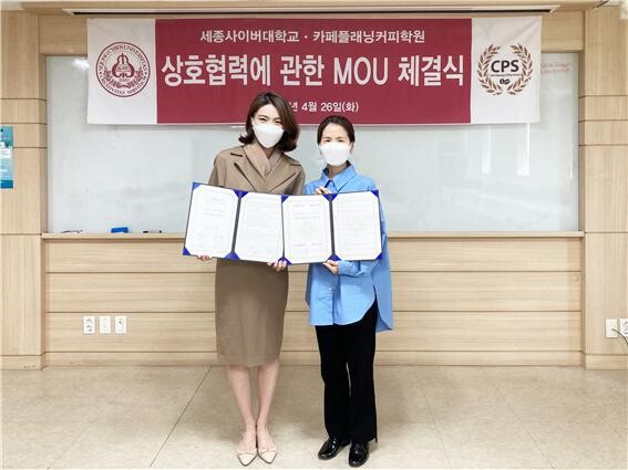 세종사이버대와 카페플래닝커피학원의 업무협약식에서 참석자들이 협약서를 펼쳐보이고 있다. 사진=세종사이버대 제공