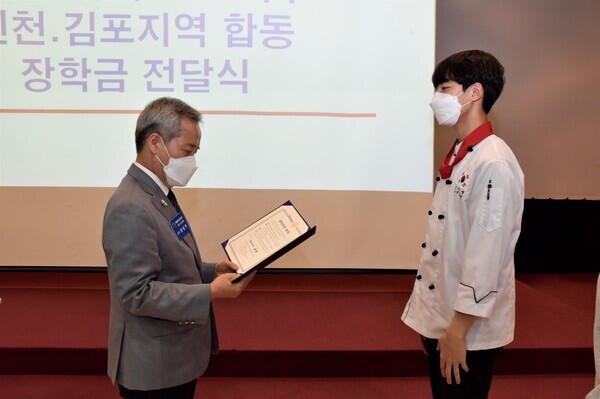 양승직(왼쪽) 국제로타리 3690지구 총재가 인천재능대 호텔외식조리과 홍덕영 씨에게 장학증서를 전달하고 있다. 사진=인천재능대 제공