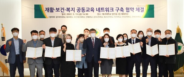 박상규(앞줄 가운데) 대구대 총장직무대행과 각 대학 혁신사업단장 등이 업무협약을 체결한 후 파이팅을 외치고 있다. 사진=대구대 제공