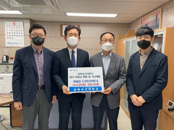 박두한(왼쪽에서 두번째) 삼육보건대 총장과 대학 관계자들이 최근 취경2동 주민센터를 방문해 독거노인 어르신들을 위한 후원금과 물품을 전달하고 기부증서를 들어보이고 있다. 사진=삼육보건대 제공