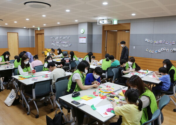 성신여대 성신 체인지 사회봉사단이 장애아동들과 함께 카네이션을 접고 편지를 쓰는 활동을 하고 있다. 사진=성신여대 제공